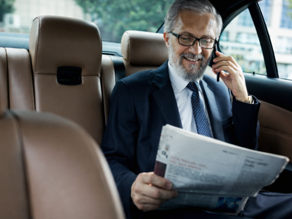 Businessman reading newspaper in car